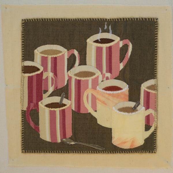 Quilt square using fabric and embroidery to show a collection of coffee mugs with tea and coffee.