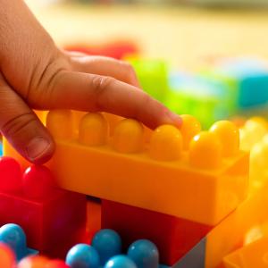 child's hand reaching for building blocks