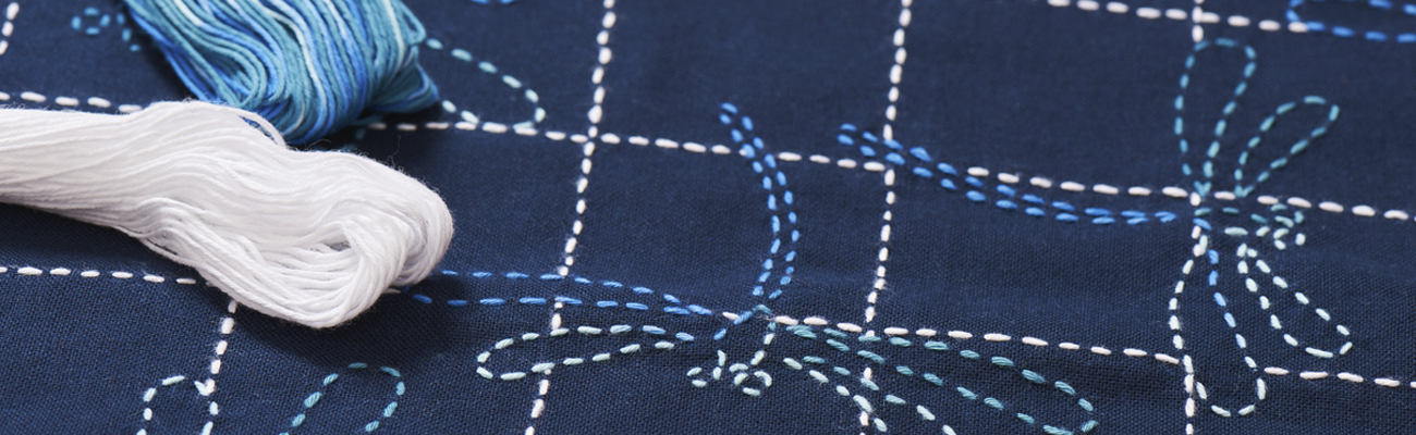 A close up shot of Shashiko stitches on blue fabric