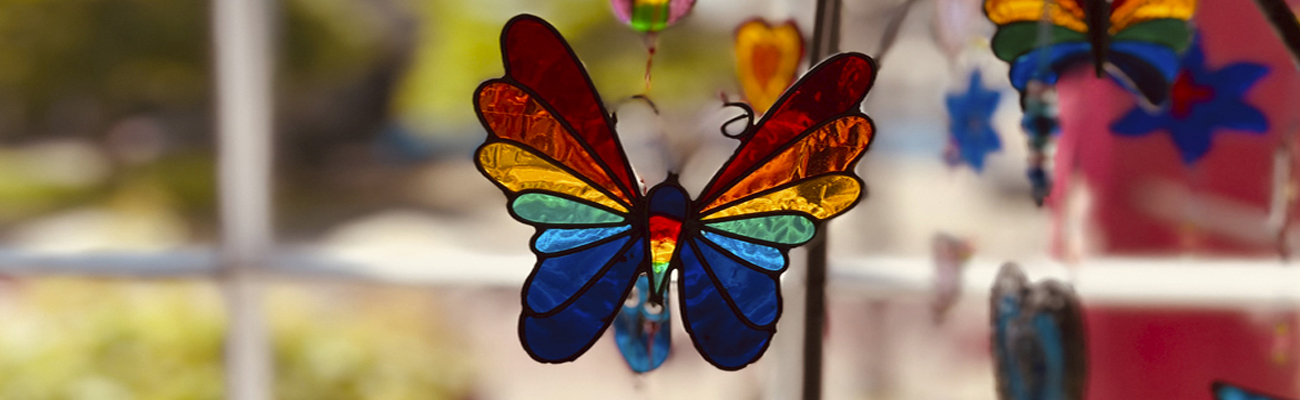 A stained glass sun catcher in the shape of a butterfly