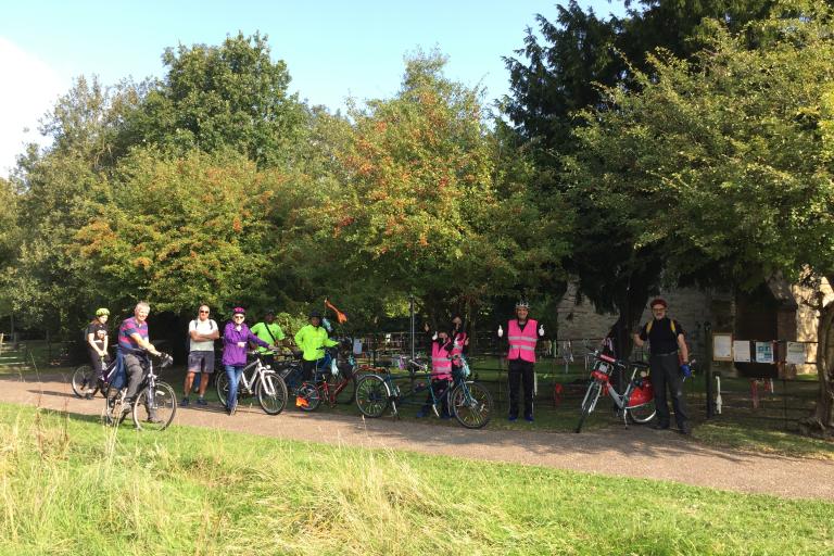 Picture of many cyclists enjoying a break outside a Church. The heritage cycle tour was part of the Heritage Open Days 2021 an annual September event held nationally. Milton Keynes has over 100 event every year.