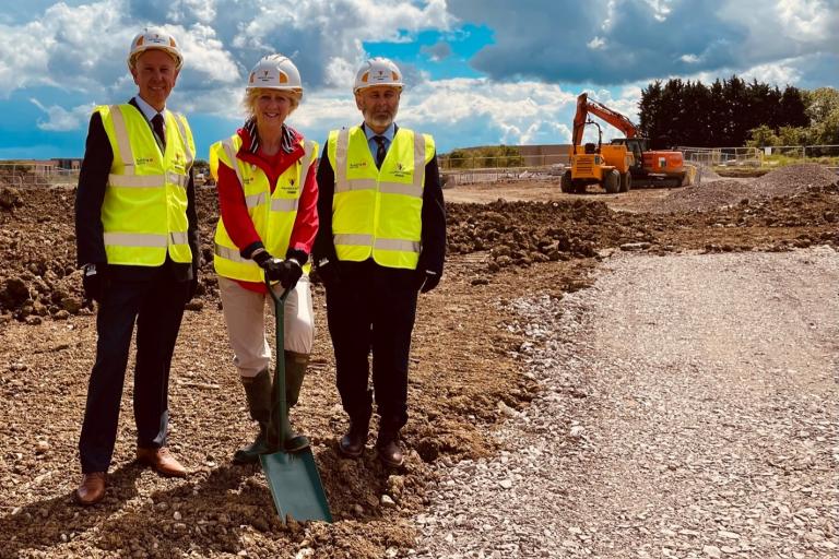 Colleagues in hard hats standing on the new site at Calverton Road