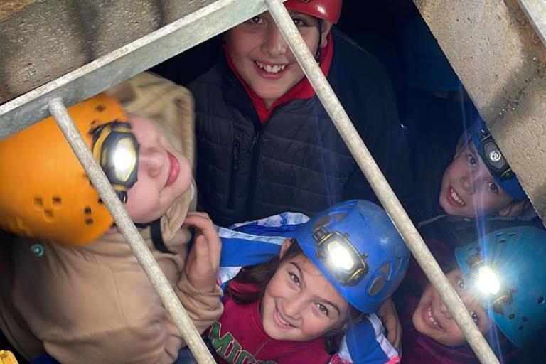 young people exploring underground tunnels during a caving session in Caldecotte