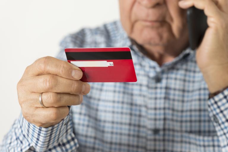 Elderly man holding a credit card