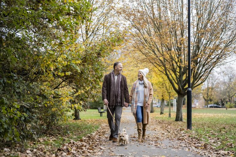 Elderly couple walking through park