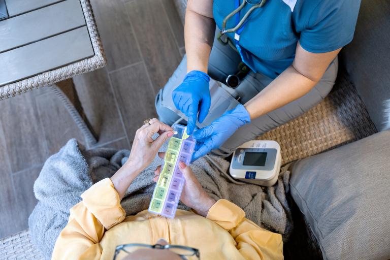 Nurse helping a patient with medicene at home