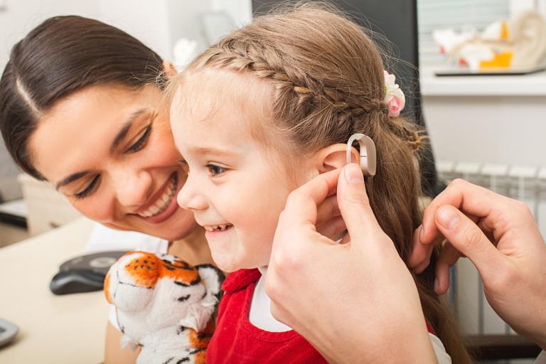 Girl receiving a hearing aid