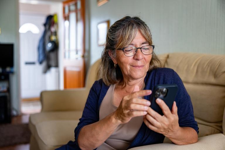 Middle aged lady using her phone at home