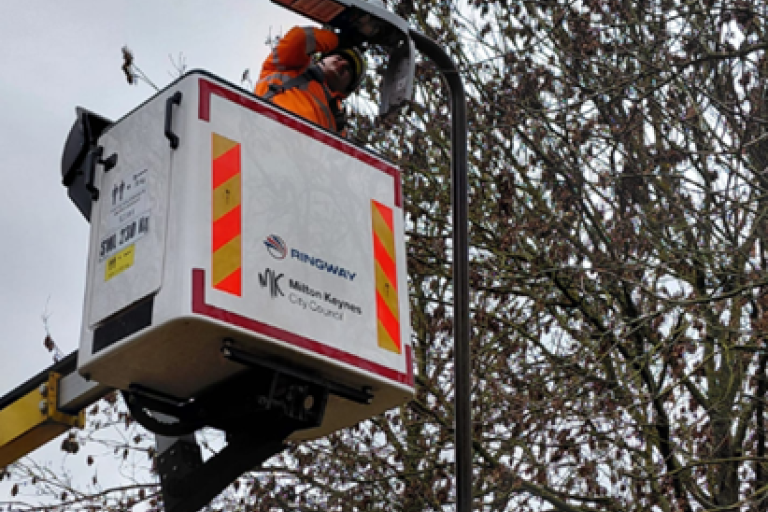 Engineer in elevated platform fixing streetlight