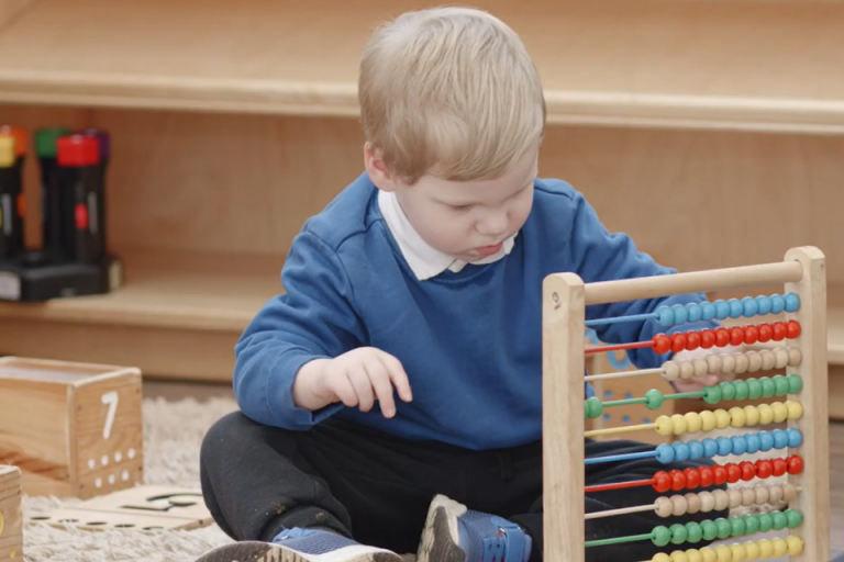 Young child playing with wooden toys at a Family Centre in MK