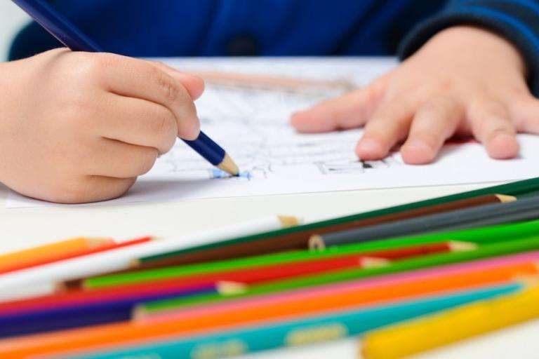 Child colouring in drawing with crayons