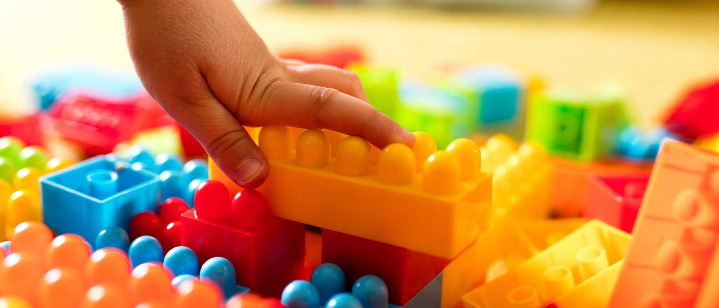 child's hand reaching for building blocks