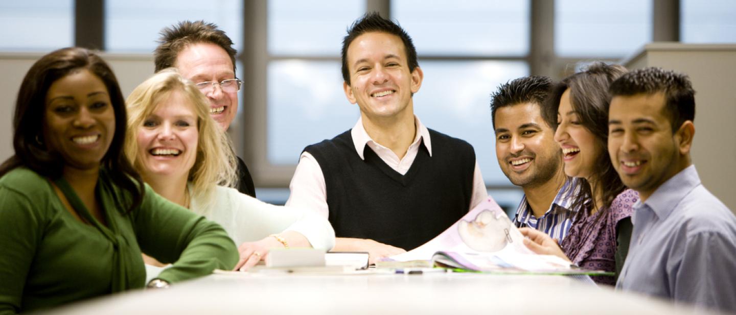 Group of smiling people chatting around a table