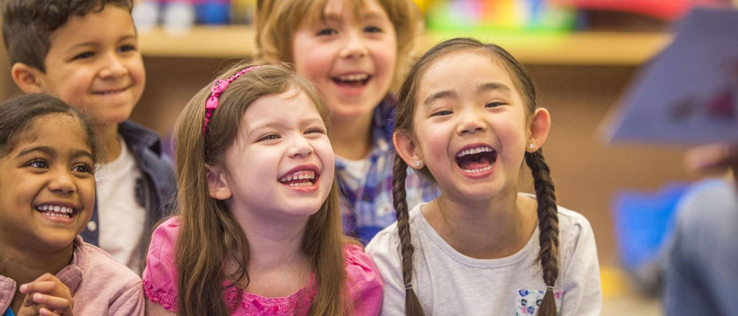 Children smiling and listening to a story