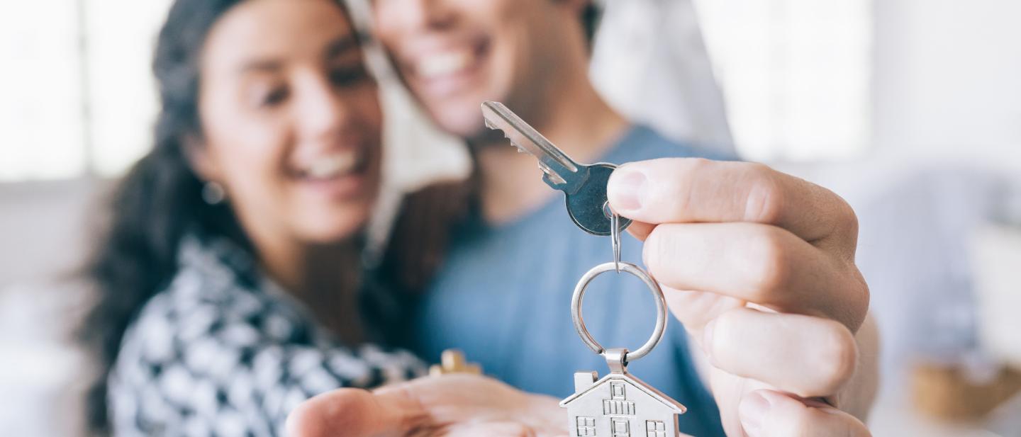 Couple holding set of keys to new home