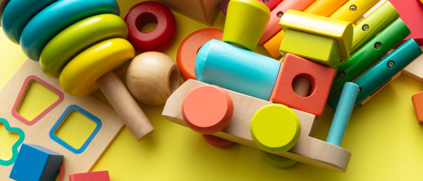 A variety of brightly painted wooden toys scattered on a table.