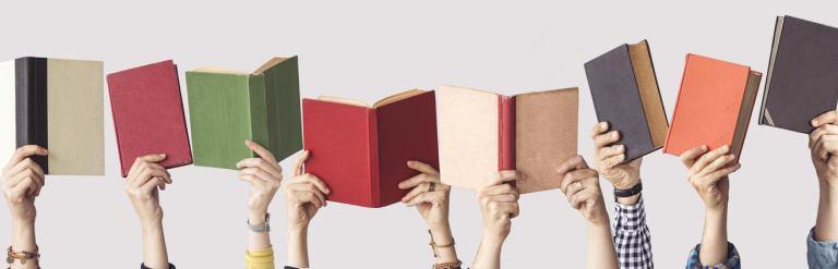 A line of hands holding up books