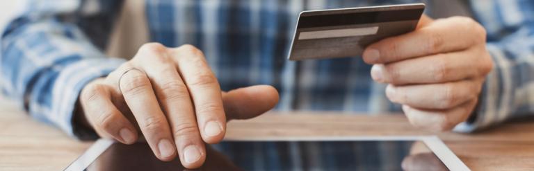 Man using credit card to make an online payment on a digital tablet