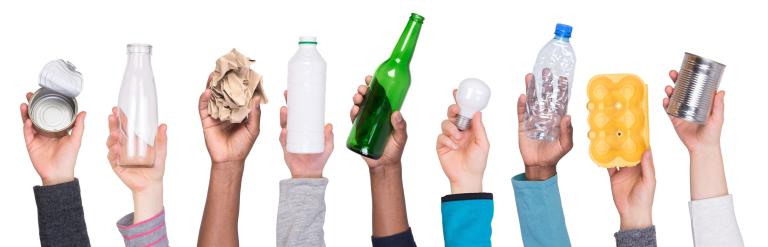 row of hands holding up various items that can be recycled