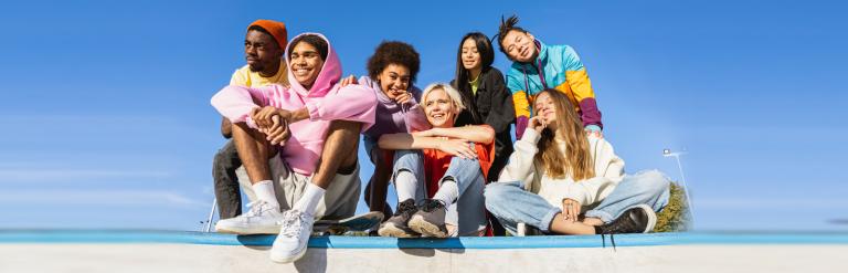 A group of teenagers sitting together and smiling.