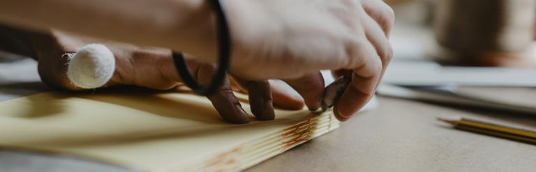 Hands binding a book