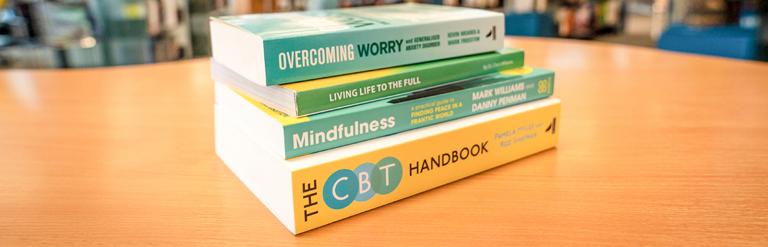 Reading Well scheme books on a table in the library.