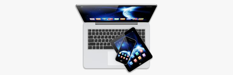 A phone and tablet resting on a laptop keyboard.