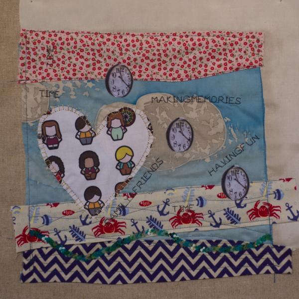 Quilt square decorated with fabric symbolising people, flowers, seaside, a map of the world and clocks. Text reads: Time, Making Memories, Family Friends, Having Fun.