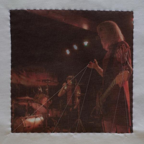 Quilt square made from printed fabric with an image of a band performing.