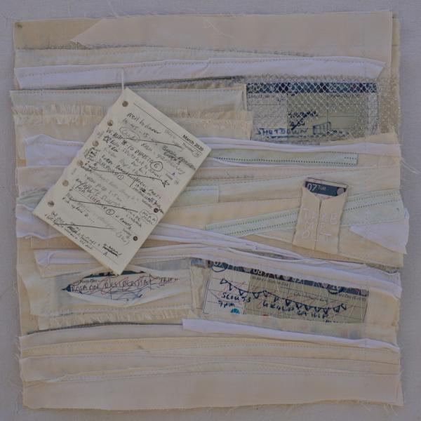 A fabric square layered with folds of fabric around snippets of calendars and diary with events all crossed out.