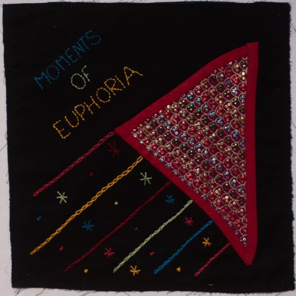 A fabric square with sequins and embroidery signifying delight. Text reads MOMENTS OF EUPHORIA