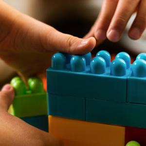 Children's hands reaching for building bricks