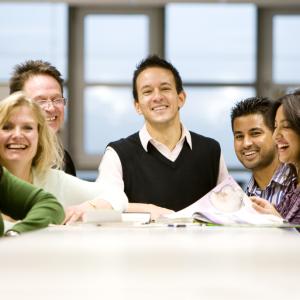 Group of smiling people chatting around a table