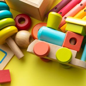 A variety of brightly painted wooden toys scattered on a table.